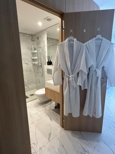 a bathroom with white towels hanging on a door at Lubina del Sol beachfront in Mijas Costa