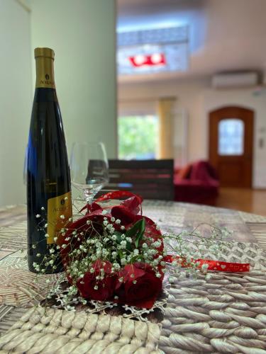 a bottle of wine and flowers on a table at HeidiHouse in Patra