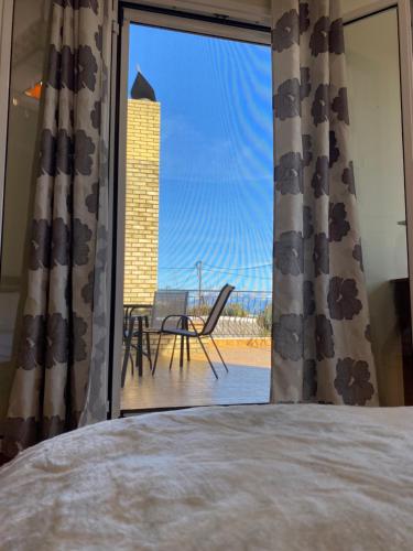 a bedroom with a window with a view of a patio at HeidiHouse in Patra