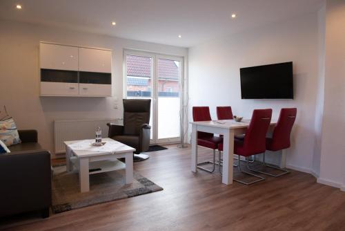 a living room with a table and chairs and a tv at Deichhaus hinten in Norden