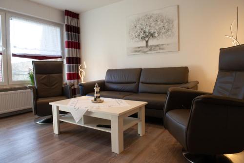 a living room with a couch and a table and chairs at Bounty in Norden