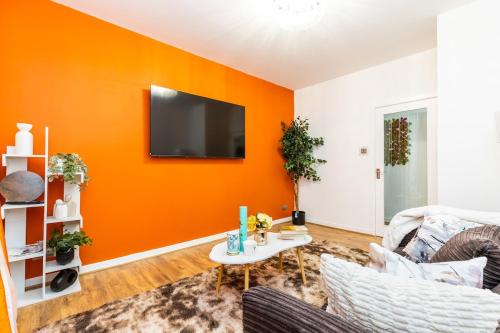 a living room with an orange accent wall at jaysapartment III in Aberdeen