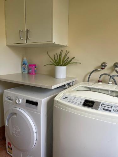 a kitchen with a washing machine and a sink at Garden View Entire Self Contained Guesthouse in Engadine