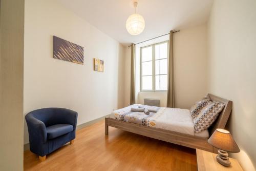 une chambre avec un lit et une chaise bleue dans l'établissement Saint nicolas - Basilique - centre ville, à Nantes