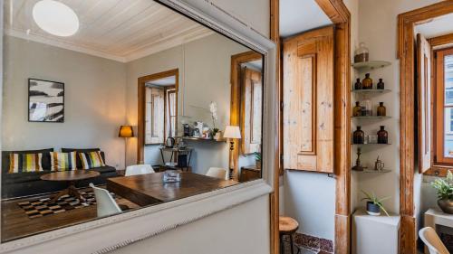 a living room with a table and a mirror at Portuguese Charm Guesthouse by LovelyStay in Lisbon