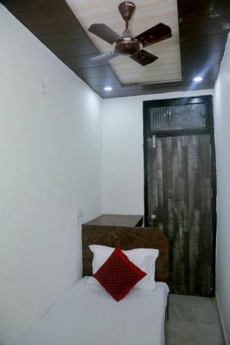 a bedroom with a white bed with a ceiling fan at Hotel Yes Please A Budget Friendly Guest House in New Delhi
