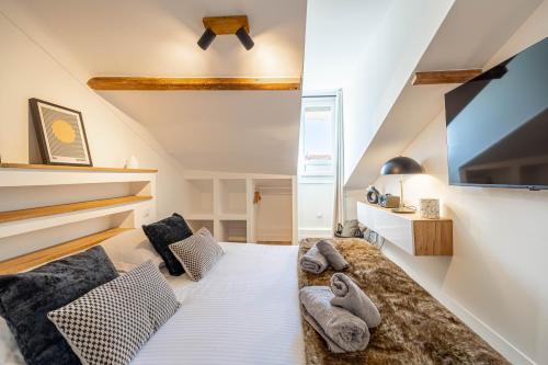 Cette chambre comprend un lit avec des oreillers et une télévision. dans l'établissement 5 CARNOT - Beautiful apartment, 4 people, 150m from Palais des Festivals, à Cannes