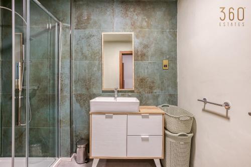 a bathroom with a sink and a shower at Beautiful 3BR designer home with WIFI, AC and Balcony in Il-Ħamrija