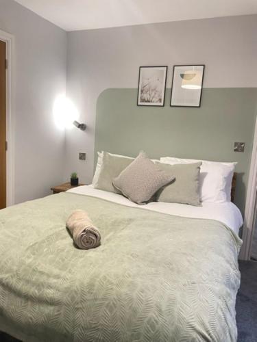 a bedroom with a large bed with a hat on it at Brand New City Centre Apartment - Free offsite Parking Available in Nottingham