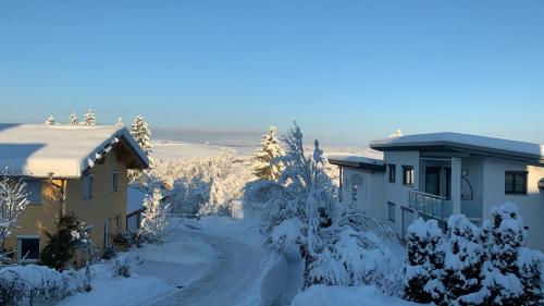 a snow covered road next to a house at Moderne Einrichtung Disney plus und prime Video im Allgäu in Sulzberg