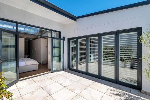 a room with sliding glass doors and a bedroom at Sea Point Luxury Escape with Private Pool in Cape Town