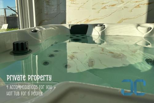 a bathroom with a tub with a sink at Arada Property - 4 Houses in 1 Private Property, Free Parking and Hot Tub in Arada