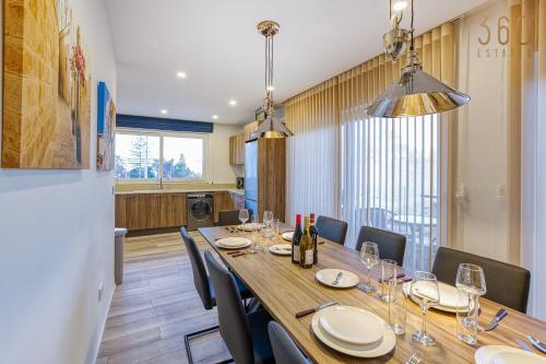 a dining room with a long table and chairs at Beautiful 3BR designer home with WIFI, AC and Balcony in Il-Ħamrija