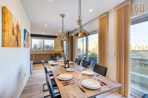 a dining room with a long wooden table and chairs at Beautiful 3BR designer home with WIFI, AC and Balcony in Il-Ħamrija