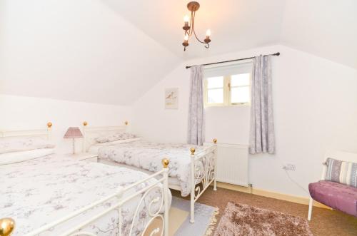 a bedroom with two beds and a window at The Hayloft in Alverstone
