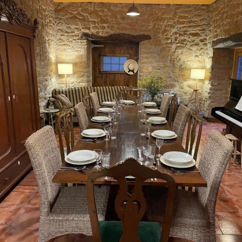 a dining room with a long table and chairs at Casa Rural Montedeio in Villamayor de Monjardín