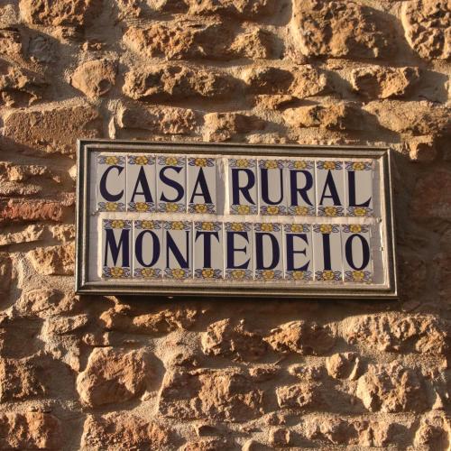 a sign on the side of a brick wall at Casa Rural Montedeio in Villamayor de Monjardín