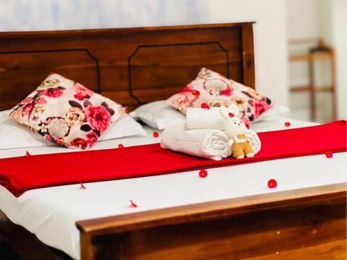 a bed with two pillows and a stuffed animal on it at Jm Resort in Dambulla