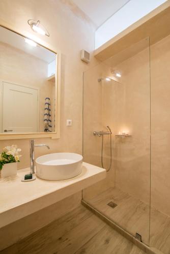 a bathroom with a sink and a glass shower at Beachfront House 50m from the beach in Mykonos