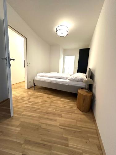 a bedroom with a bed and a wooden floor at COHO City Apartments mit hauseigener Tiefgarage in Vienna