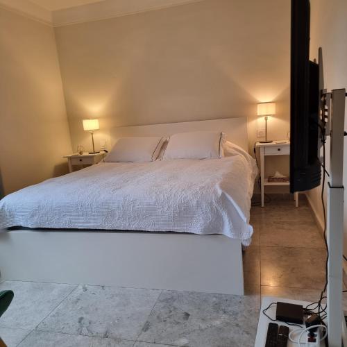 - une chambre avec un lit blanc et 2 tables de chevet dans l'établissement Villa Echauguette, Chambre et toilette privee Maison partagee avec la proprietaire, à Six-Fours-les-Plages
