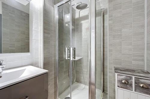 une salle de bain avec une douche en verre et un lavabo dans l'établissement Le Graziot - Appartement face à l'étang du Grazel, à Gruissan