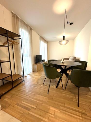 a dining room with a table and green chairs at COHO City Apartments mit hauseigener Tiefgarage in Vienna