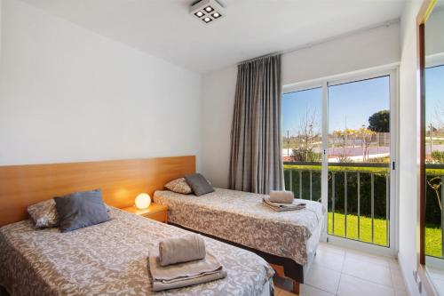 カバナス・デ・タビラにあるCosta Cabanas 54のバルコニー付きの客室内のベッド2台