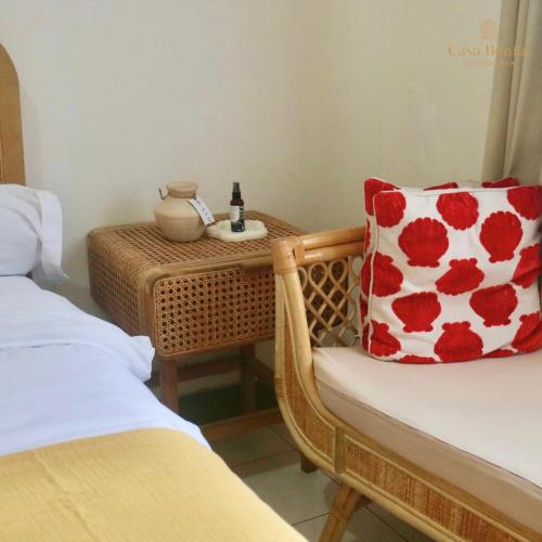 a room with a bed and a chair with a pillow at Casa Bonita: Stylish, Affordable Home & Mini Pool in Kalasan