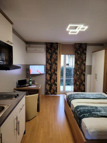 a bedroom with a bed and a kitchen with a sink at apartmentHAUSmannstätten in Hausmannstätten