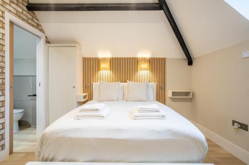 a bedroom with a large white bed with towels on it at Paradise Apartments in York