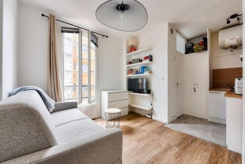 un salon avec un canapé et une cuisine dans l'établissement Charming studio Paris Levallois Perret, à Levallois-Perret