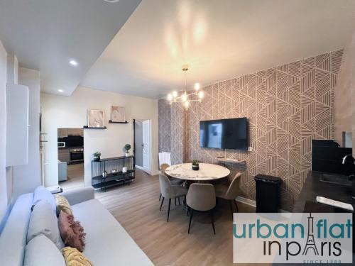 un salon avec une table et une télévision dans l'établissement 06 - Richer, à Paris