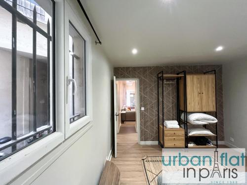 un couloir avec une chambre dotée d'une fenêtre et d'une chaise dans l'établissement 06 - Richer, à Paris