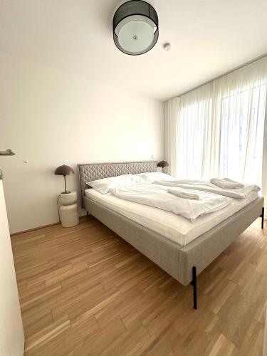 a bedroom with a bed and a large window at COHO City Apartments mit hauseigener Tiefgarage in Vienna