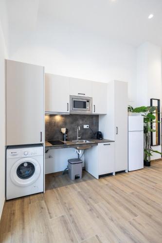 a kitchen with white cabinets and a washing machine at Les Arts Plaza by Concept Flats in Valencia