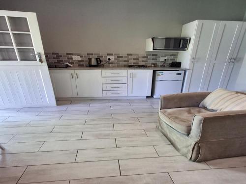 a living room with a couch and a kitchen at Rainbow Glen Self Catering Chalets in Montagu