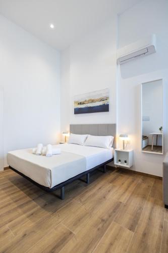 a bedroom with a large white bed and a mirror at Les Arts Plaza by Concept Flats in Valencia
