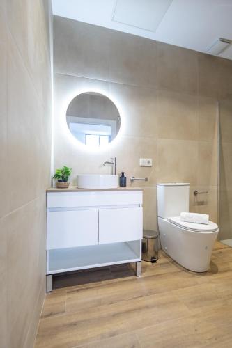 a bathroom with a sink and a toilet and a mirror at Les Arts Plaza by Concept Flats in Valencia
