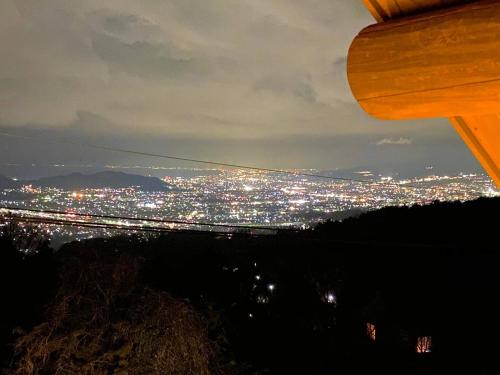 a view of a city lit up at night at A Private Log House with Mt Fuji View & Piano - "Thangtong House Japan" in Kannami