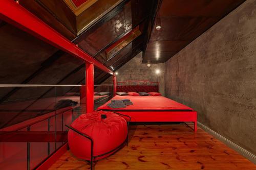 a bedroom with a red bed in a attic at Masoch. Hotel & Cafe in Lviv