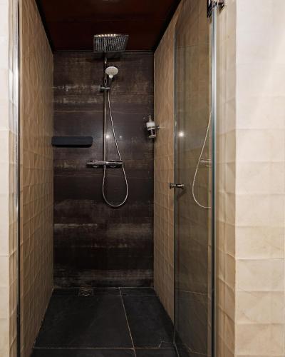 a shower with a glass door in a bathroom at Masoch. Hotel & Cafe in Lviv