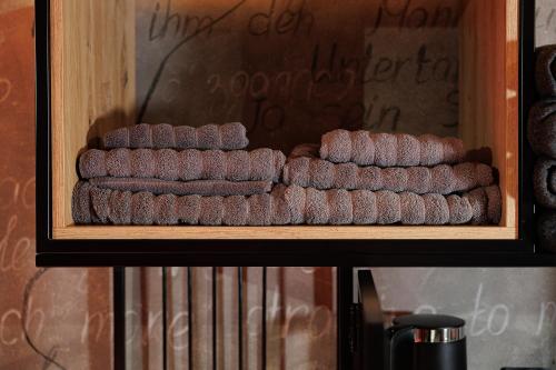 a shelf with a pile of chocolateuts in a box at Masoch. Hotel & Cafe in Lviv