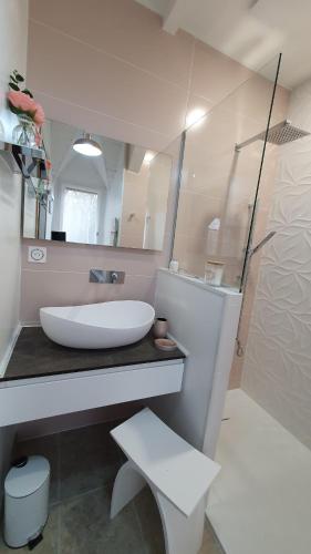 a white bathroom with a sink and a mirror at La Maison de Judith Chambres d hôtes in Orthez