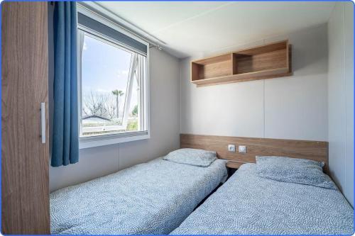 Rúm í herbergi á MOBIL HOME LE LUMINEUX VALRAS