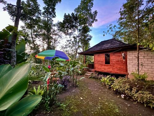 a house with a colorful umbrella in front of it at Green Escape in Tetebatu
