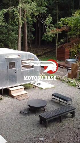 a trailer parked next to a picnic table and benches at 本栖ベース～ヴィンテージトレーラーとバレルサウナ’1日1組限定’の貸切別荘～ in Fujikawaguchiko
