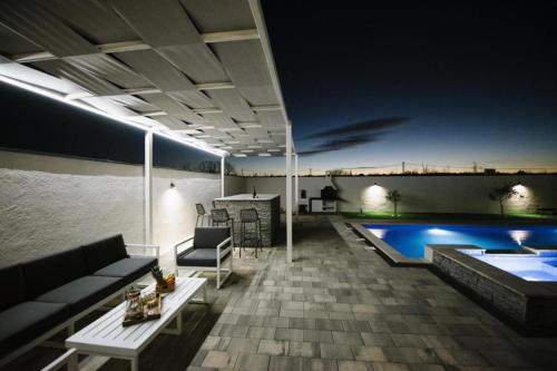 a patio with a couch and a pool at night at Luxury Villa Blue Sky in Široki Brijeg