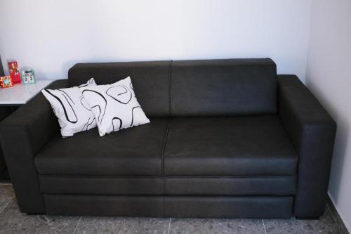 a black couch with two white pillows on it at Luxury Villa Blue Sky in Široki Brijeg
