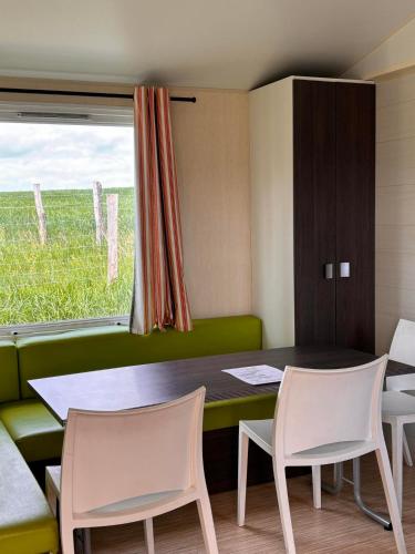 une pièce avec une table, des chaises et une fenêtre dans l'établissement Le Camping de Ripan, à Bessenay